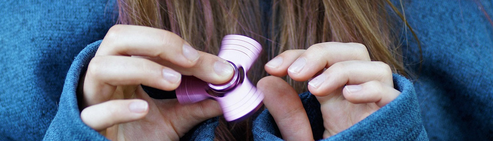 a person holding a pink fidget spinner-fun fidgets a person holding a pink fidget spinner-fun fidgets