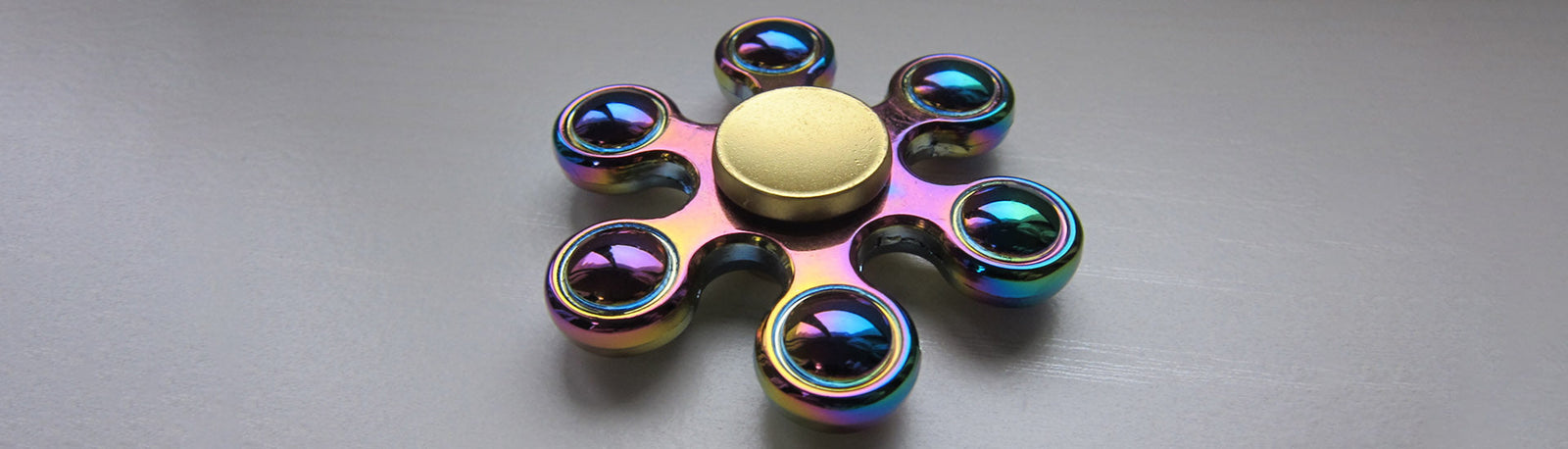 metallic fidget spinner on a grey background-fun fidgets metallic fidget spinner on a grey background-fun fidgets
