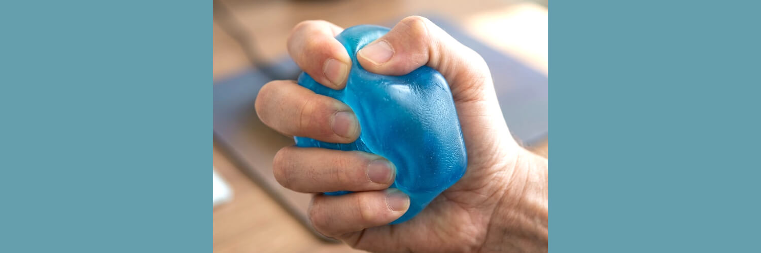 an image of a hand squeezing a blue needoh nice cube-fun fidgets
