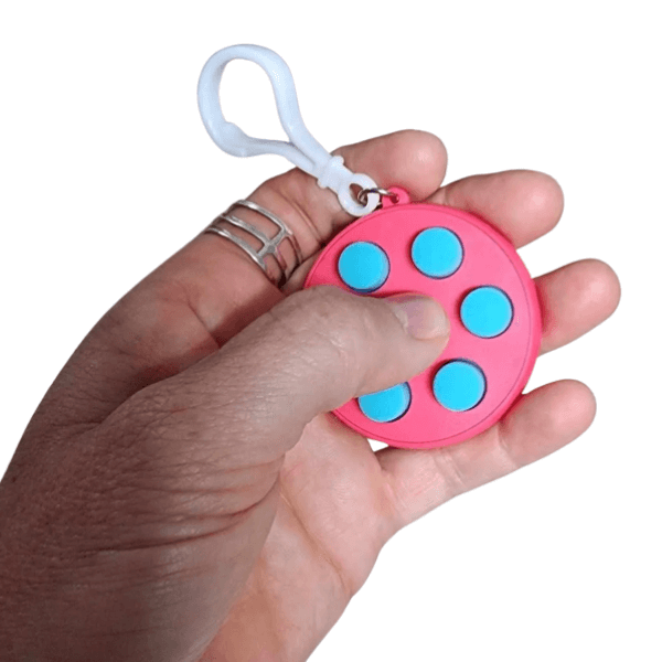 someone holding a pink fidget clicker-fun fidgets