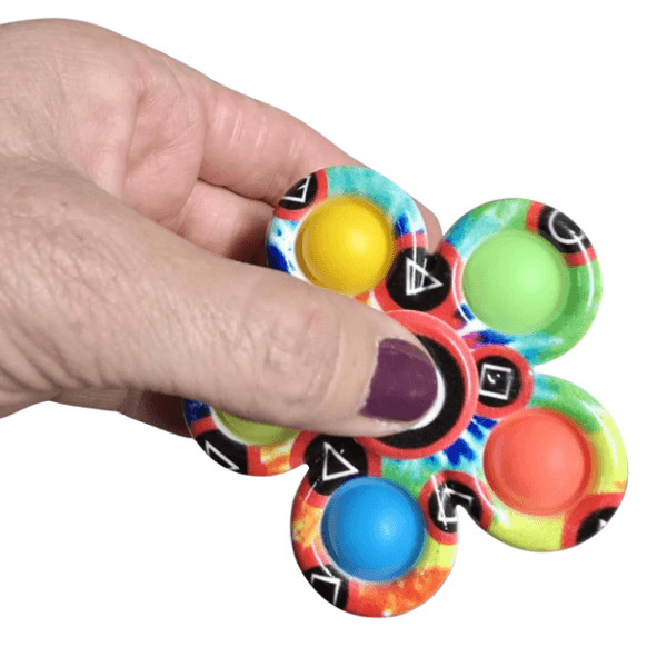 pop it spinner shown being held between thumb and finger-fun fidgets